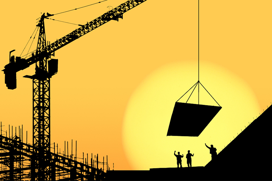 Construction workers on site during sunset